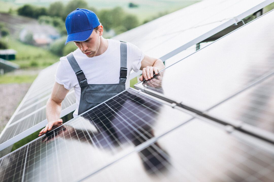 Un operario coloca placas solares en un tejado